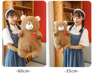 Plush bear detail view showing size comparison with cute heart embroidery and soft brown fur.