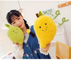 Morbidi peluche di frutta sorridenti tenuti da una modella in casa accogliente