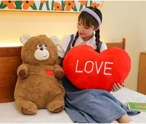 Cute brown teddy bear plush toy with red love heart pillow, perfect Valentine's day gift for girls.