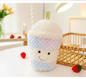 Vista ravvicinata di un simpatico peluche a forma di bubble tea con faccina e trama morbida.