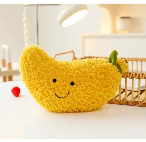 Peluche creativo a forma di frutto giallo con una simpatica faccina ricamata su tavolo