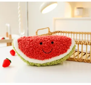 Dettaglio ravvicinato di un peluche a forma di anguria con una simpatica faccina sorridente