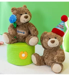Morbidi orsetti di peluche marroni con cappello di compleanno e decorazione floreale blu