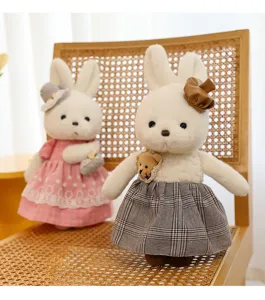 Close-up of cute white rabbit plush dolls wearing stylish pink and plaid fabric dresses