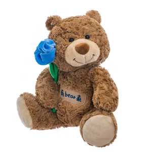 Adorabile morbido orsacchiotto di peluche marrone con una bella rosa di velluto blu