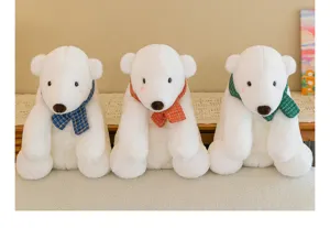 Three soft polar bear plush toys wearing colorful checkered scarves displayed on a shelf