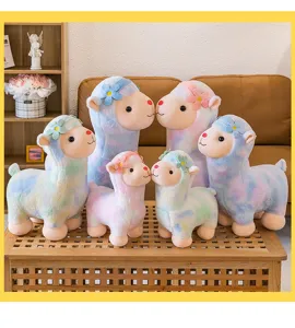 Variety of soft and colorful rainbow alpaca plush toys in multiple sizes on a table