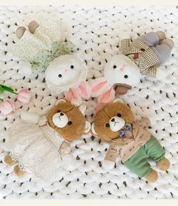 Primer plano de adorables osos y conejitos de peluche con ropa elegante sobre una manta