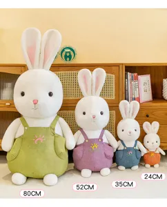 Vier maten witte konijnen knuffels met kleurrijke overalls in een binnenomgeving