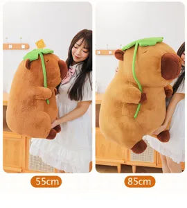 Vista dettagliata che confronta le taglie di peluche capybara 55 cm e 85 cm con foglia