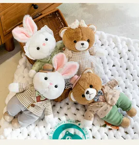 Colección de lindos peluches de ositos y conejitos con ropa elegante sobre una manta tejida