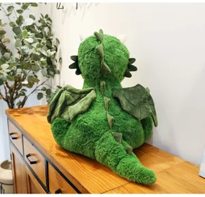 Süßes grünes Plüschdrache Spielzeug Detailansicht, weiche Stofftier Dinosaurier Puppe auf Schrank.