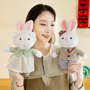Par de adorables peluches de conejo con ropa elegante sostenidos por una modelo