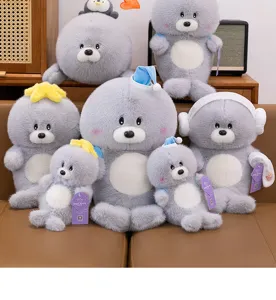 Primer plano de varios simpáticos leones marinos de peluche grises con accesorios de invierno