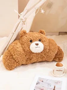 Primer plano de un cojín de peluche de oso con forma de cruasán en una habitación acogedora