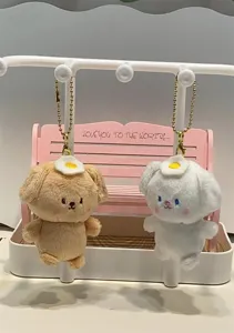Mignons porte-clés chien en peluche avec œuf au plat sur un banc rose miniature