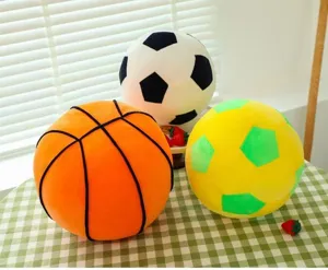 Detailed view of soft plush football and basketball pillows on a green checkered table
