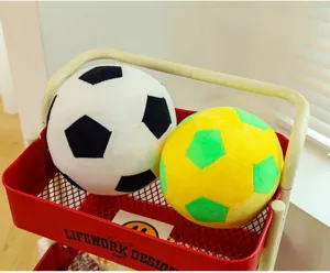 Detailed view of soft plush soccer ball pillows in black and yellow color combinations
