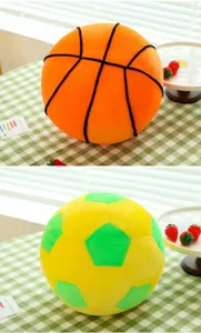 Detailed view of plush basketball and soccer ball-shaped throw pillows on a table.