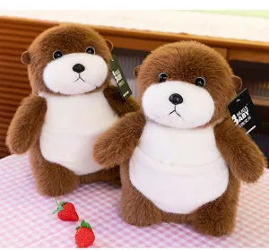 Close-up of two realistic sea otter plush toys with soft brown fur on checkered table