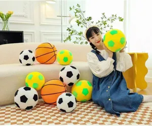 Soft soccer and basketball plush toy pillows displayed in a cozy indoor setting