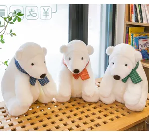 Three white polar bear plush toys with colorful plaid scarves on wooden bench