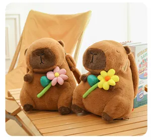 Detailed view of two cute brown capybara plush backpacks holding colorful flowers