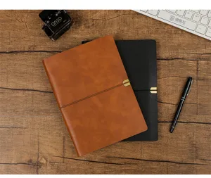 Vue de dessus de deux carnets A5 à feuilles mobiles en cuir marron et noir sur un bureau en bois
