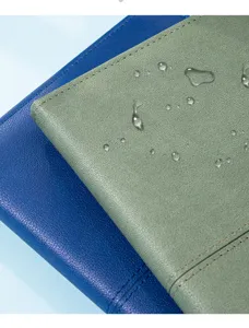 Detailopname van waterbestendige lederen notebookhoes met druppels die duurzaamheid tonen.