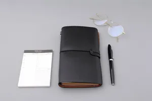 Vintage A6 Notizbuch aus Kunstleder mit Gummibandverschluss auf einem minimalistischen Tisch