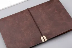 Detailaufnahme eines braunen A6-Notizbuchs aus Kunstleder mit sicherem Gummibandverschluss.