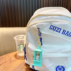 Close-up of mint green lantern shaker keychain with rabbit doll on white bag