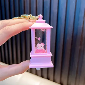 Detailed view of a pink lantern keychain featuring floating liquid sand and a cute cat figurine.