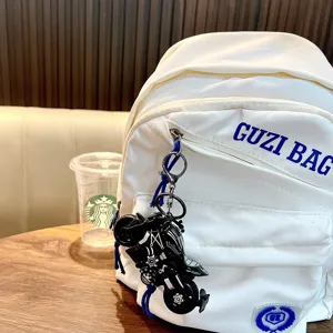 Porte-clés moto en alliage noir suspendu à un sac à dos blanc