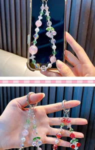 Close-up detail of handcrafted alloy cherry beaded phone charm with sparkling rhinestones