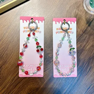 Delicate cherry beaded phone strap and keychain with sparkling rhinestones on card