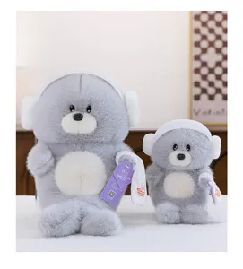 Detalle de dos lindos peluches de león marino gris con gorros de ducha y toallas blancas