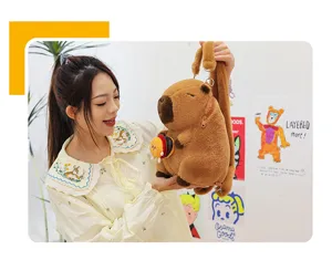 Detailed view of a cute brown plush capybara backpack held by a model in a lifestyle setting