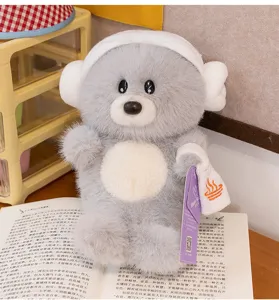 Primer plano de un lindo peluche de león marino gris con piel suave sobre un libro