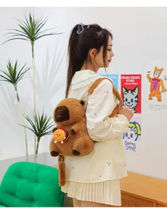 Cute capybara plush backpack with burger charm accessory shown in lifestyle setting
