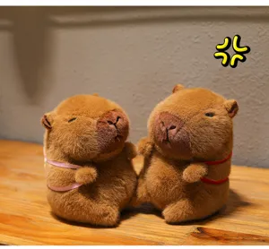 Detailed view of two adorable brown capybara plush dolls sitting on a wooden surface