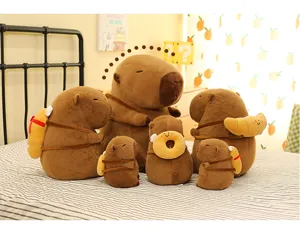 Gruppe von Capybara-Plüschtieren mit rucksackförmigem Essen auf dem Bett