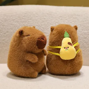 Cute brown Capybara plush toy with a small yellow pear-shaped backpack on a soft surface