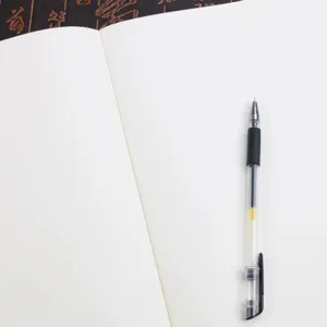 Detalle de las páginas blancas de un cuaderno A5 vintage con un bolígrafo transparente