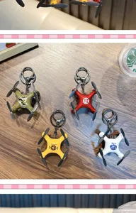 Gedetailleerd beeld van vier kleurrijke mini drone model sleutelhangers op hout.
