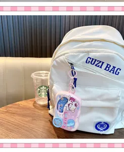 Cute cat game console keychain pendant paired with a stylish white canvas casual student backpack.