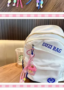 Detaillierte Makroansicht eines rosa Erdbeer-Cupcake-Schlüsselanhängers an einem Rucksack