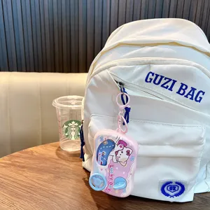Cute cartoon water game machine keychain paired with a white backpack, student fashion accessory.