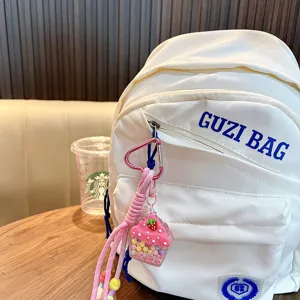 Süßer Erdbeereis-Öl-Shaker-Schlüsselanhänger, der an einem weißen Rucksack hängt