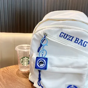 Simpatico portachiavi a molla con astronauta blu appeso a uno zaino bianco sportivo